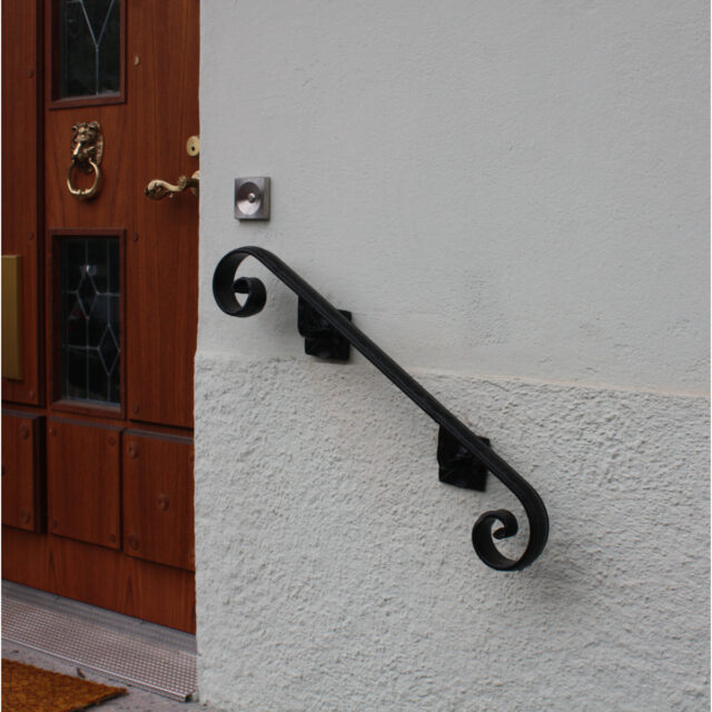 Musta käsijohde seinään. TAkorautainen käsijohde.